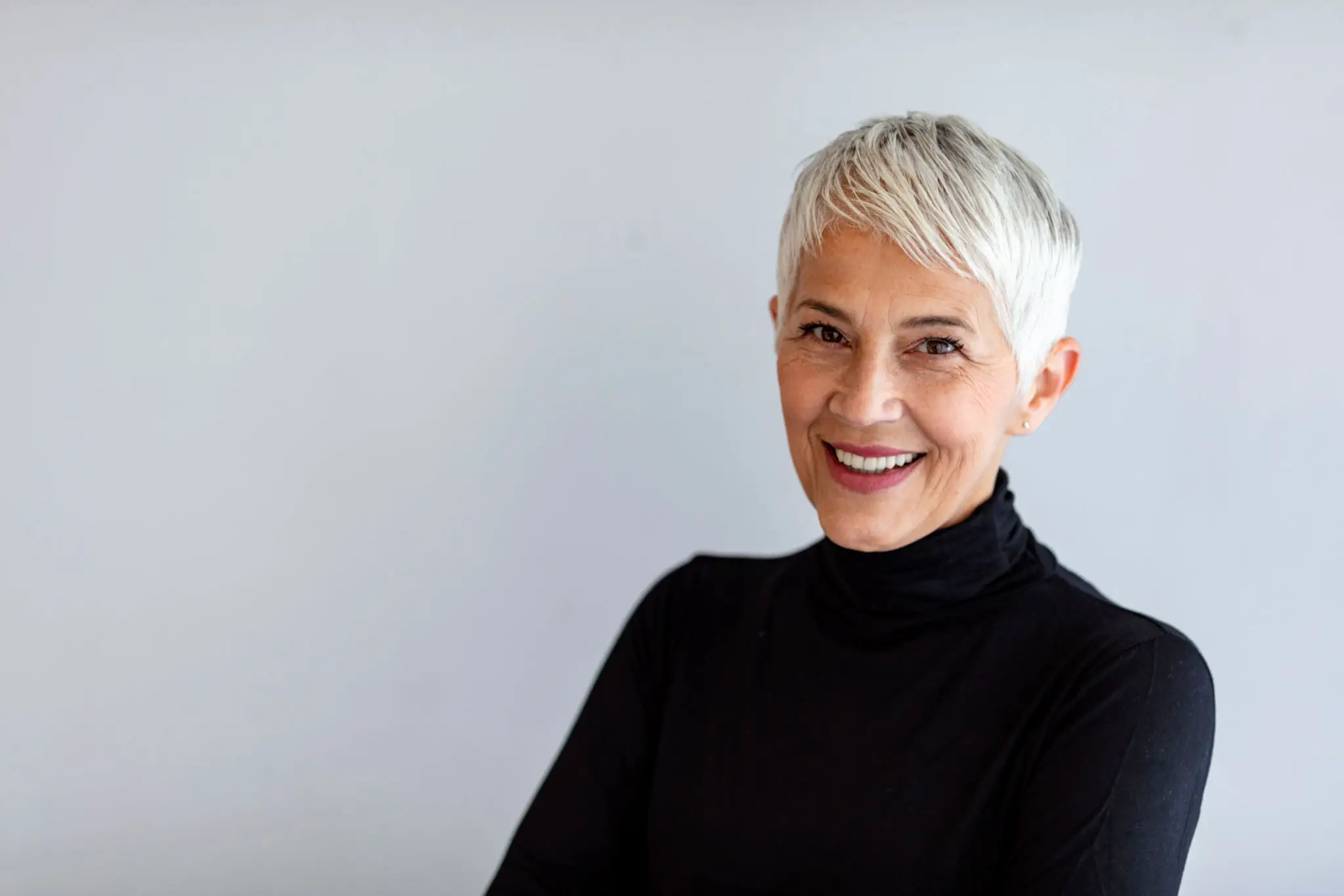 Portrait of smiling woman with short white hair